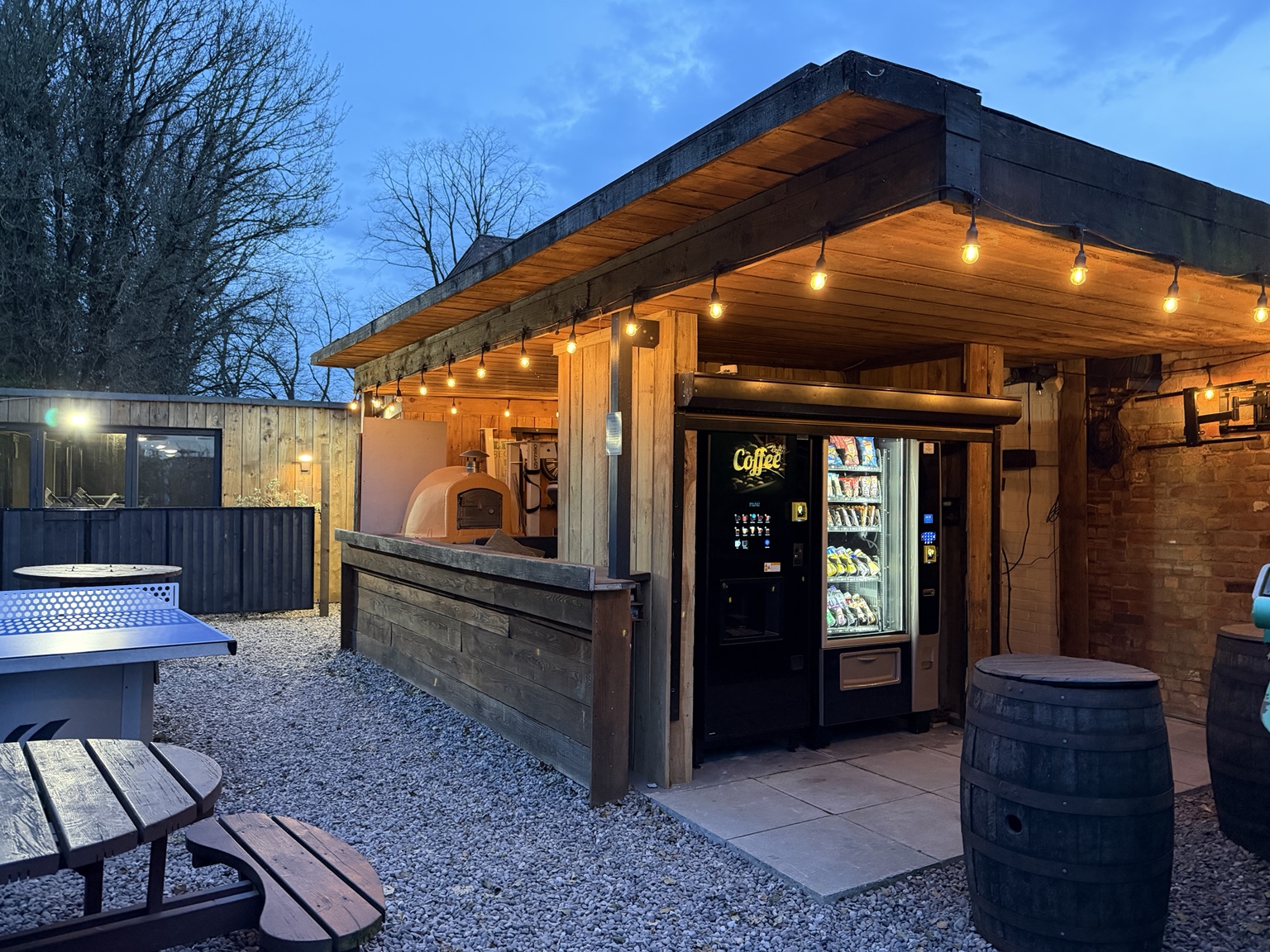 Timber-clad outdoor drinks area with warm lights and courtyard seating